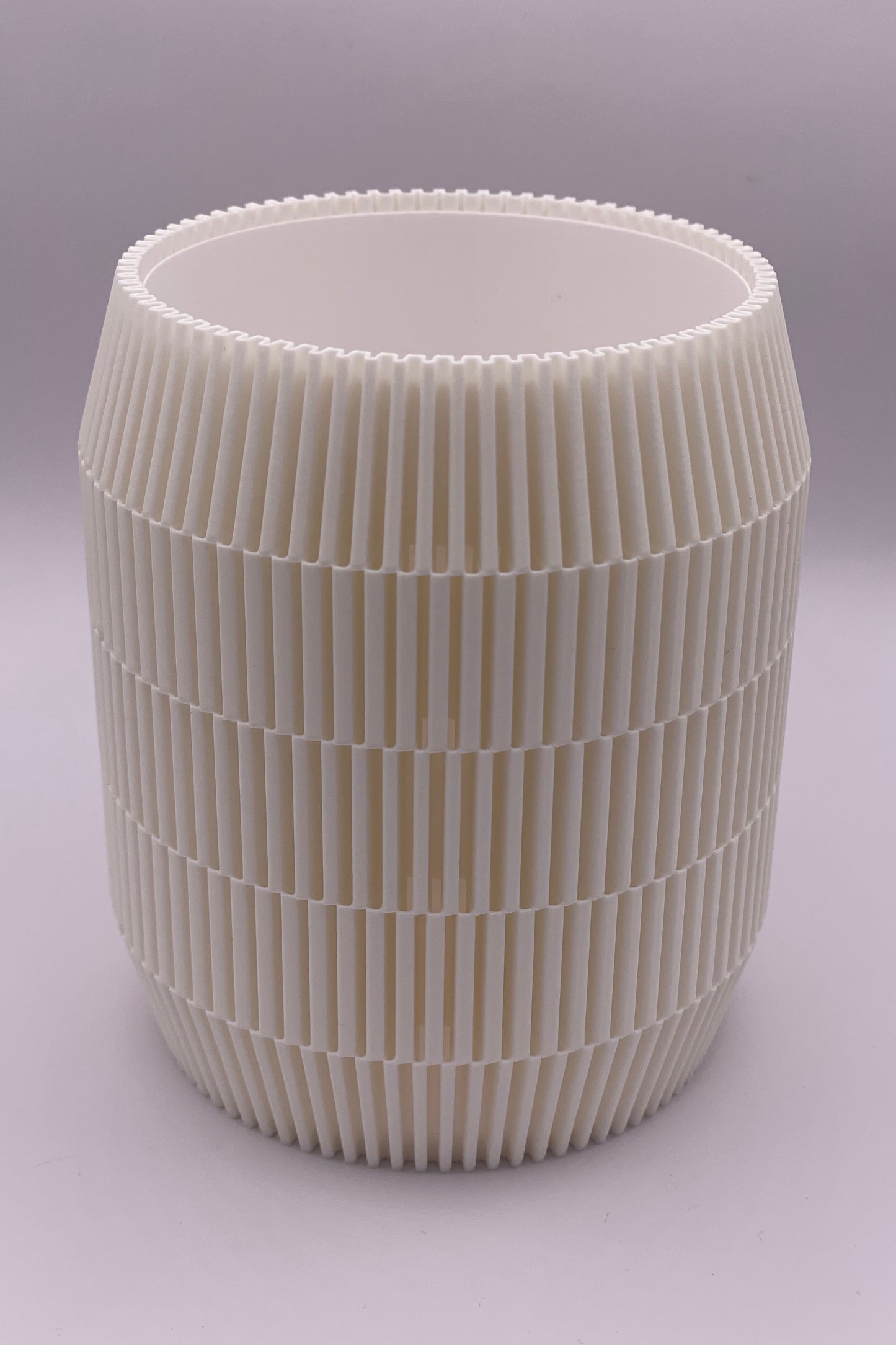 Modern lampskärm i cylinderform med geometriskt rutmönster som sprider ljus jämnt.