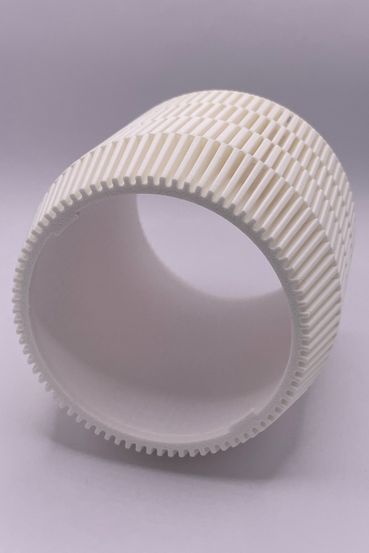 Modern lampskärm i cylinderform med geometriskt rutmönster som sprider ljus jämnt.